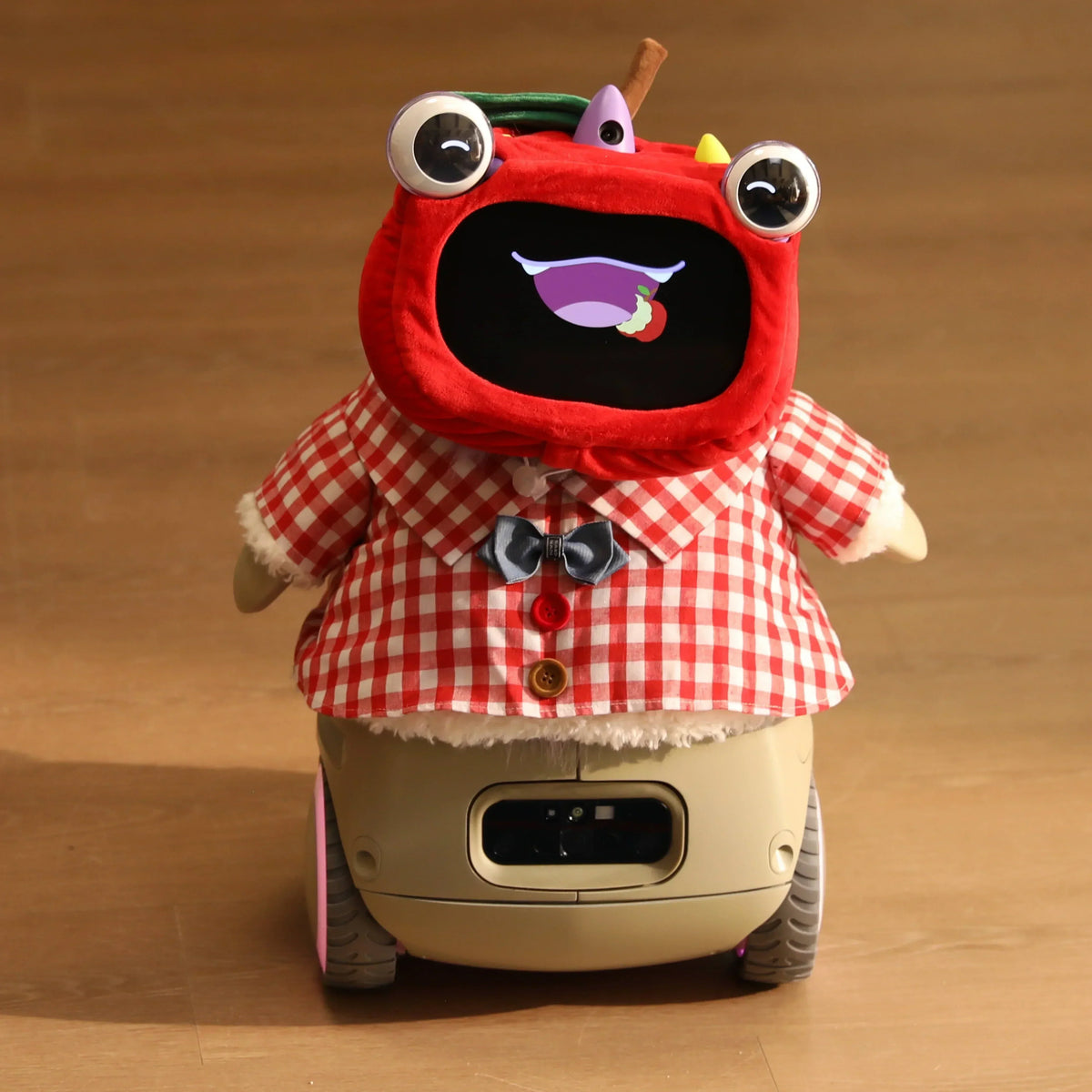 Plush red-hooded robot pet on wheels with a screen face and gingham shirt