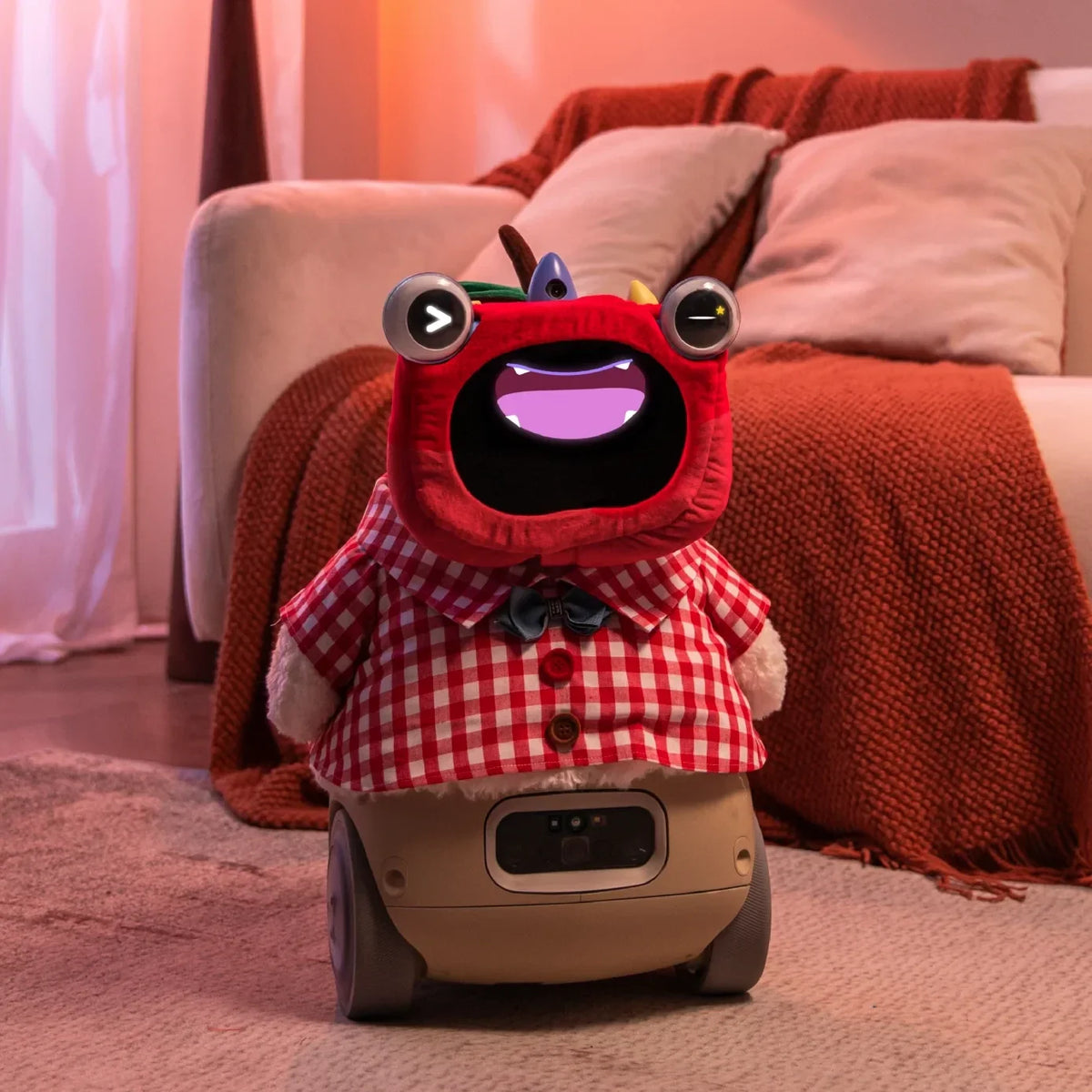 Plush wheeled robot pet with red hood, checkered shirt, and bow tie on carpet near sofa.